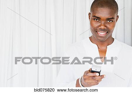 African man smiling and holding remote control View Large Photo Image Stock Image - African man smiling and holding remote control. Fotosearch