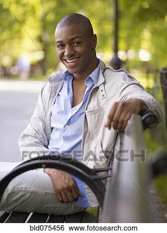 African man smiling on bench View Large Photo Image Stock Photograph - African man smiling on bench. Fotosearch
