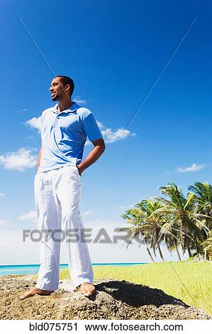 African man standing on rock near ocean View Large Photo Image Stock Image - African man standing on rock near ocean. Fotosearch