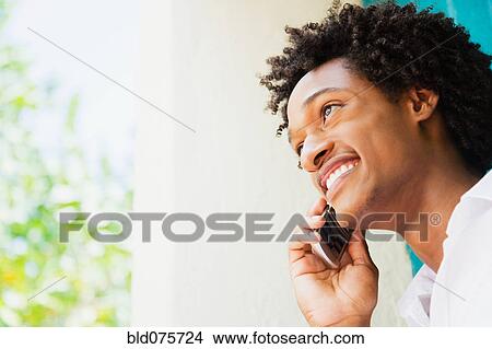 Picture - African man talking on cell phone. Fotosearch