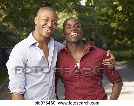 Stock Image - African men hugging and smiling. Fotosearch