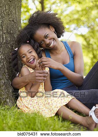 African mother and daughter hugging in park View Large Photo Image Stock Image - African mother and daughter hugging in park. Fotosearch