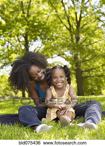 Stock Photograph - African mother and daughter hugging in park. Fotosearch