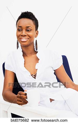 African woman drinking coffee in armchair View Large Photo Image Stock Image - African woman drinking coffee in armchair. Fotosearch