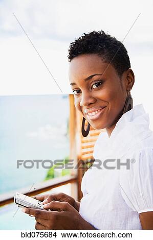 African woman holding cell phone View Large Photo Image Picture - African woman holding cell phone. Fotosearch