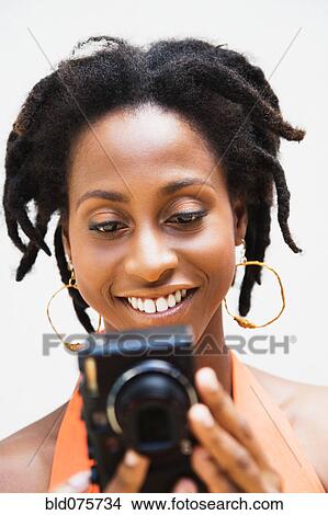 African woman holding digital camera View Large Photo Image Picture - African woman holding digital camera. Fotosearch