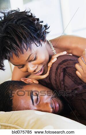 Stock Photography - African woman hugging sleeping man. Fotosearch