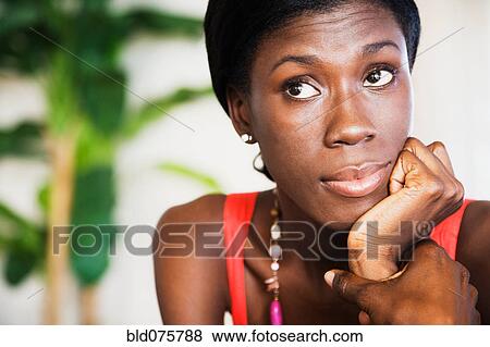 Stock Photo - African woman looking up with head in hands. Fotosearch