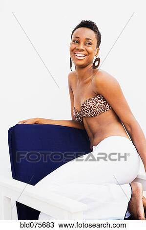 African woman smiling in armchair View Large Photo Image Stock Image - African woman smiling in armchair. Fotosearch