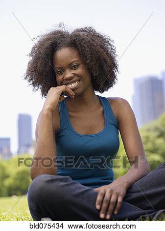 Picture - African woman smiling in park. Fotosearch
