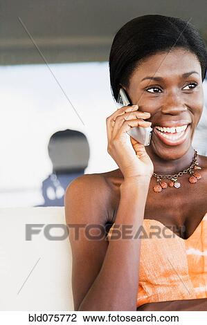Stock Image - African woman talking on cell phone. Fotosearch