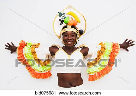 Stock Image - African woman wearing traditional clothing and standing with arms outstretched. Fotosearch