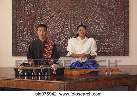 Stock Image - Asian man and woman with traditional musical instruments. Fotosearch