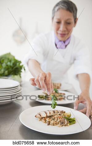 Chinese chef plating meals in professional kitchen View Large Photo Image Stock Photo - Chinese chef plating meals in professional kitchen. Fotosearch