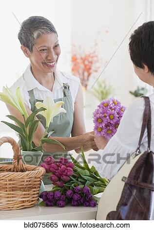 Stock Photography - Chinese florist giving flowers to customer. Fotosearch