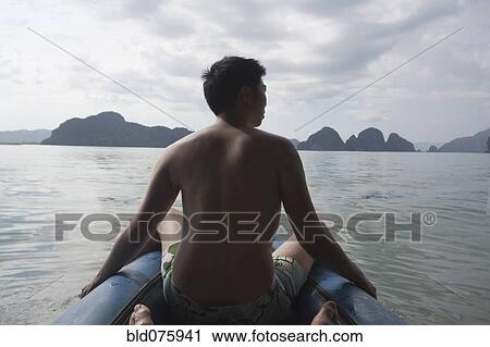 Stock Image - Chinese man on boat in ocean. Fotosearch