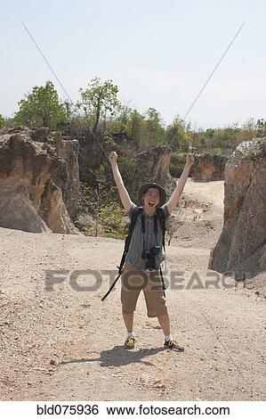 Chinese tourist laughing with arms raised View Large Photo Image Stock Photograph - Chinese tourist laughing with arms raised. Fotosearch