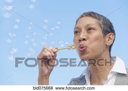 Stock Photo - Chinese woman blowing bubbles. Fotosearch
