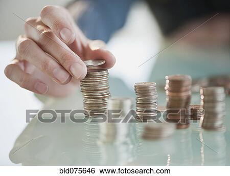 Stock Photograph - Close up of Hispanic woman stacking coins. Fotosearch