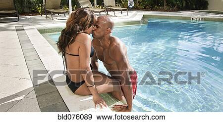 Stock Photo - Couple kissing at edge of swimming pool. Fotosearch