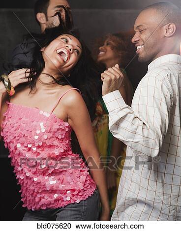 Stock Image - Couples dancing at nightclub. Fotosearch