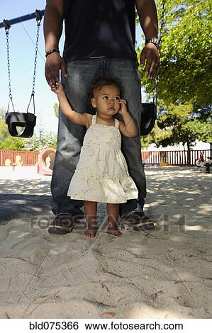 Father and barefoot daughter at playground View Large Photo Image Stock Photograph - Father and barefoot daughter at playground. Fotosearch