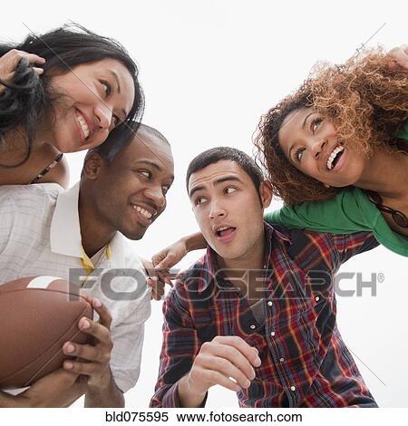 Friends holding football in huddle View Large Photo Image Stock Photography - Friends holding football in huddle. Fotosearch