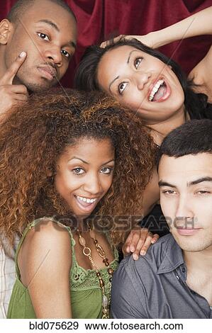 Stock Photo - Friends making faces in photo booth. Fotosearch