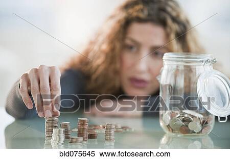 Hispanic woman counting coins from jar View Large Photo Image Stock Photography - Hispanic woman counting coins from jar. Fotosearch