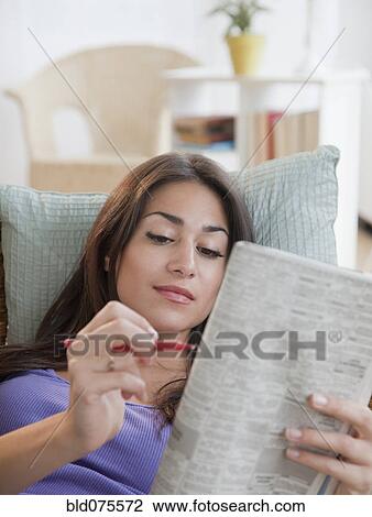 Hispanic woman doing newspaper crossword puzzle View Large Photo Image Stock Image - Hispanic woman doing newspaper crossword puzzle . Fotosearch