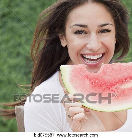 Stock Photo - Hispanic woman eating watermelon. Fotosearch