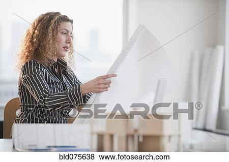 Hispanic woman looking at blueprints View Large Photo Image Stock Photo - Hispanic woman looking at blueprints. Fotosearch