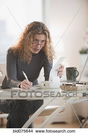 Hispanic woman paying bills View Large Photo Image Picture - Hispanic woman paying bills. Fotosearch