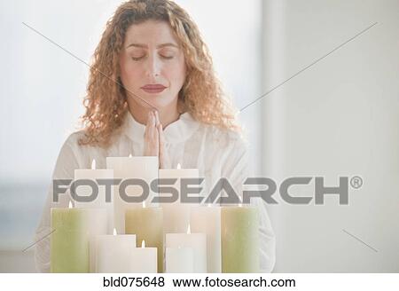 Hispanic woman praying by candles View Large Photo Image Stock Photo - Hispanic woman praying by candles. Fotosearch