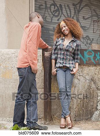 Stock Photo - Man and woman flirting on urban street. Fotosearch