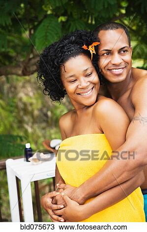 Stock Image - Man hugging woman wrapped in a towel. Fotosearch