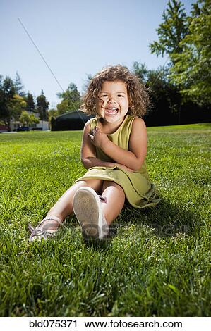 Stock Image - Mixed race girl laughing in park. Fotosearch