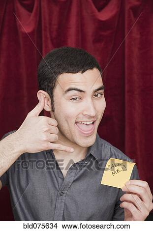 Mixed race man holding Call Me sticky note and gesturing View Large Photo Image Picture - Mixed race man holding Call Me sticky note and gesturing. Fotosearch