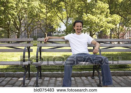 Mixed race man smiling on park bench View Large Photo Image Stock Image - Mixed race man smiling on park bench. Fotosearch
