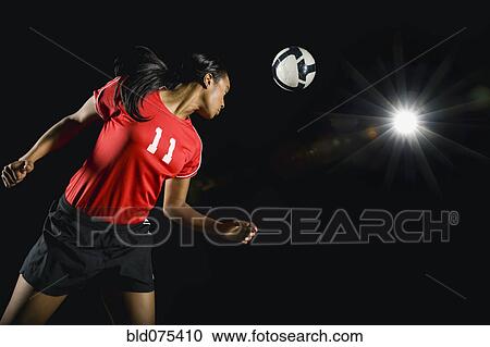 Soccer ball above mixed race soccer player View Large Photo Image Stock Image - Soccer ball above mixed race soccer player. Fotosearch