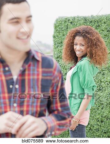 Woman smiling at passing man View Large Photo Image Stock Photo - Woman smiling at passing man. Fotosearch