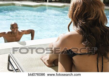 Stock Photograph - Woman watching man in swimming pool. Fotosearch