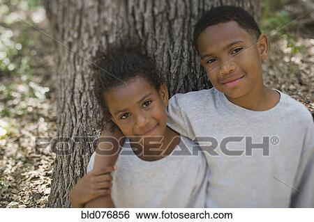 African boy and girl hugging against tree View Large Photo Image Stock Photograph - African boy and girl hugging against tree. Fotosearch