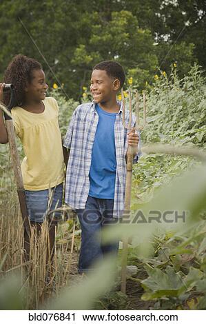 Stock Image - African boy and girl in garden. Fotosearch