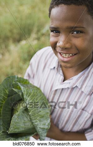 African boy holding cabbage View Large Photo Image Stock Image - African boy holding cabbage. Fotosearch