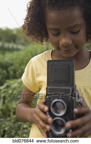 African girl holding retro camera in garden View Large Photo Image Picture - African girl holding retro camera in garden. Fotosearch