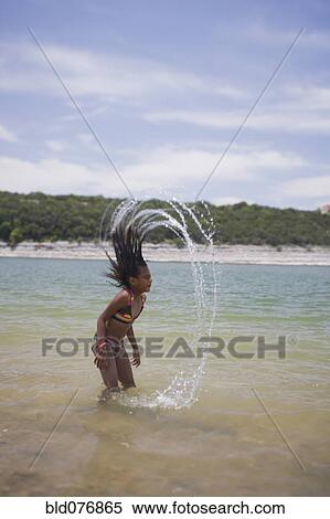 Stock Photography - African girl splashing hair in lake. Fotosearch