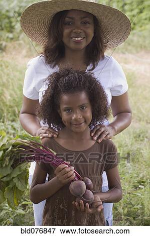 African mother and daughter holding beets in garden View Large Photo Image Stock Photo - African mother and daughter holding beets in garden. Fotosearch