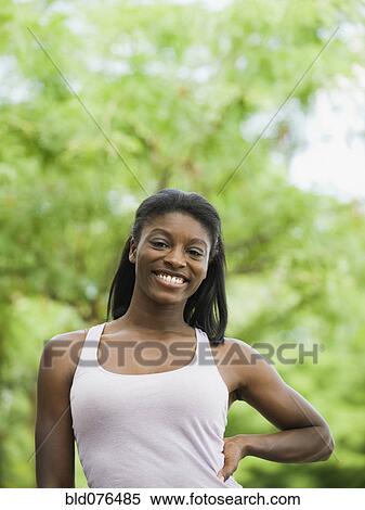 Stock Photography - African woman smiling with hand on hip. Fotosearch
