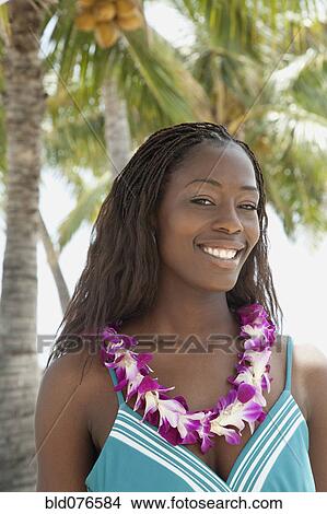 Picture - African woman wearing lei on beach. Fotosearch